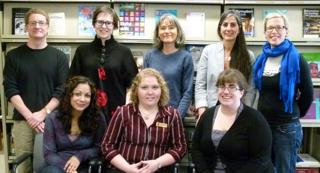 Library staff in front of shelves of periodicals