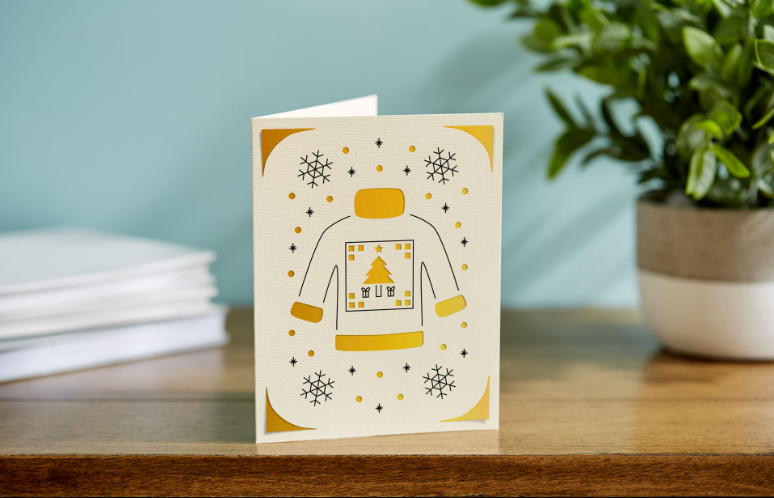 Beige and yellow card with a christmas sweater and snowflakes