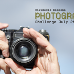 Image with hands holding camera and the text "Wikimedia Photography Challenge July 2025."